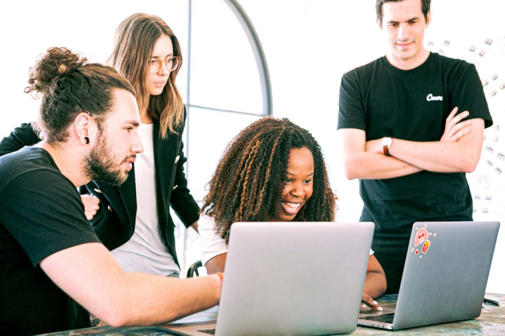 Freelancers reviewing self-employment paperwork on laptops in a Barcelona coworking space