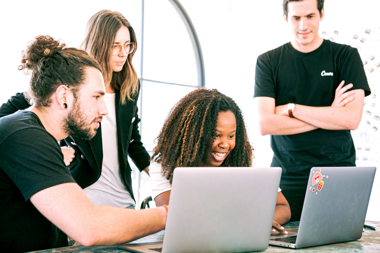Freelancers reviewing self-employment paperwork on laptops in a Barcelona coworking space